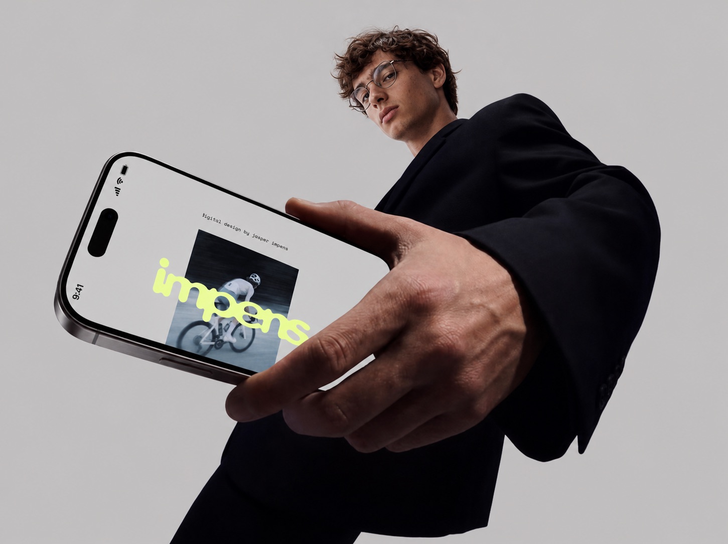 Jasper holding a phone showing the impens. site